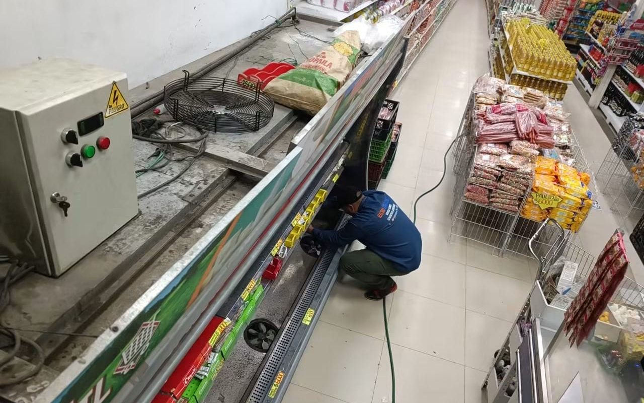 Técnico de Electroreparaciones realizando mantenimiento a un equipo de refrigeración comercial