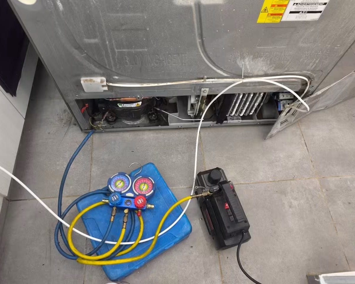 Carga de gas refrigerante y prueba de vacío en una nevera durante el servicio a domicilio
